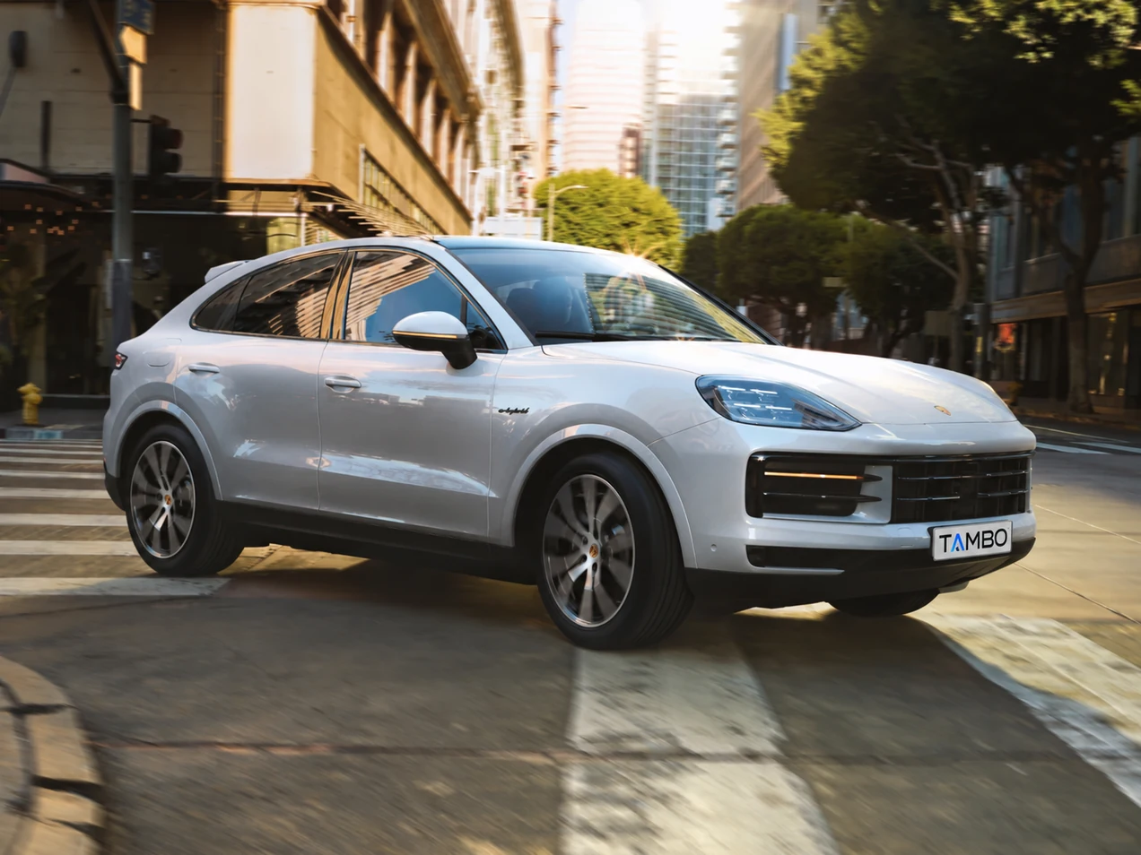 Porsche Cayenne Coupé bianca, vista di tre quarti in movimento in città